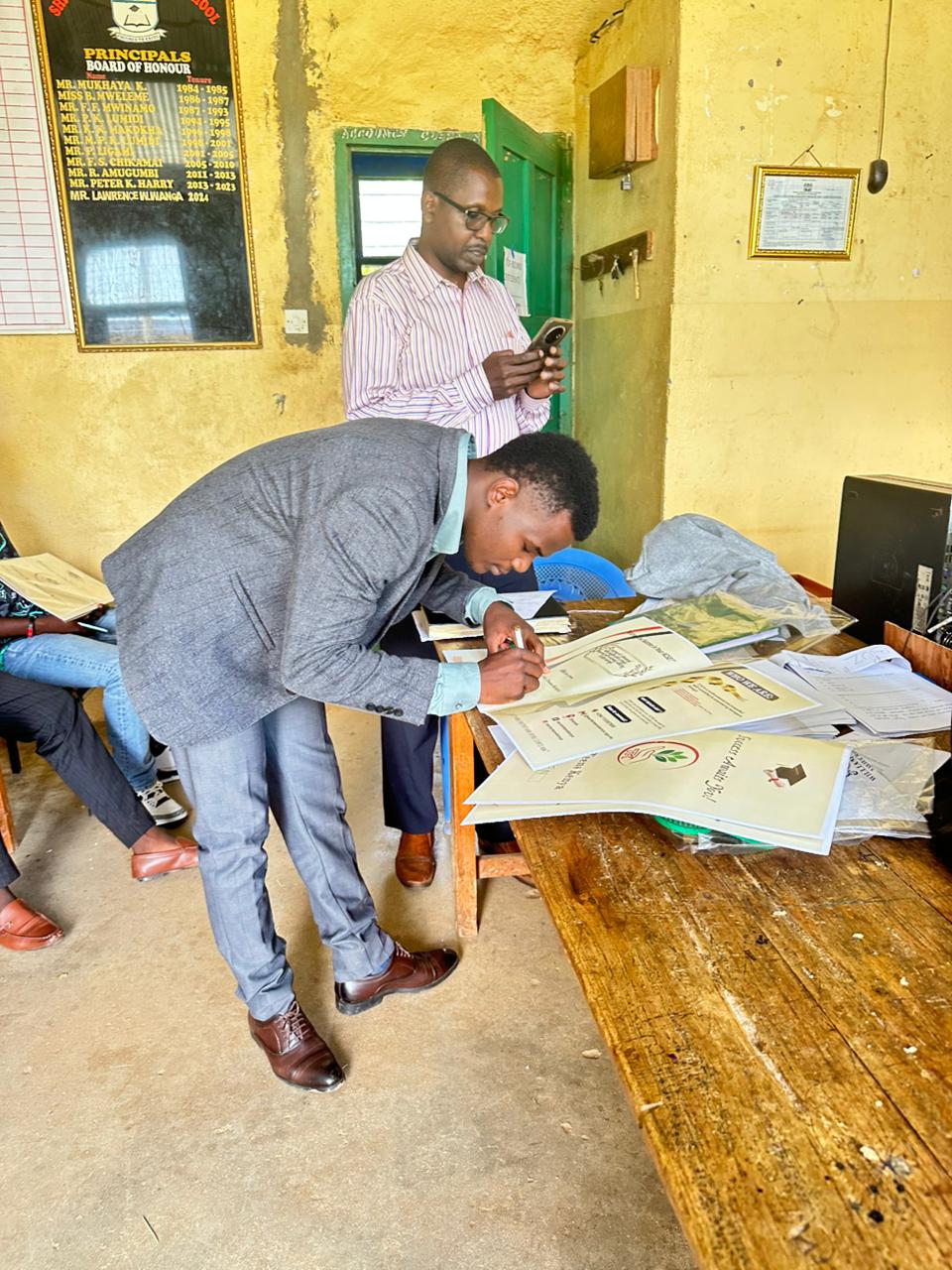 CEO signing cards in teacher's office
